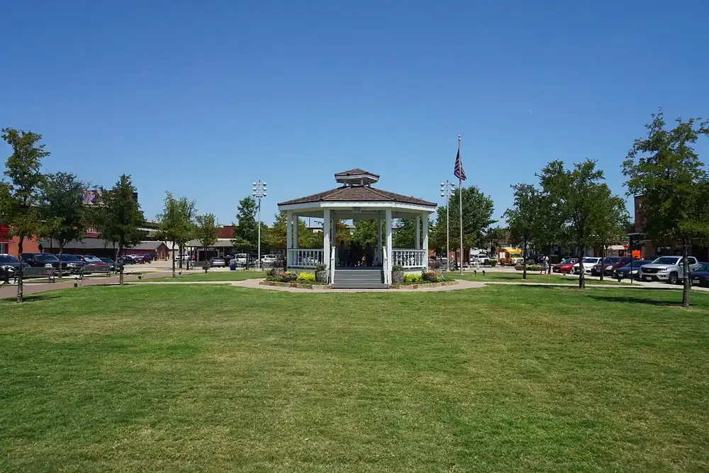 White gazebo on the lawn of Carrollton Square under a blue sky in Carrollton, Texas