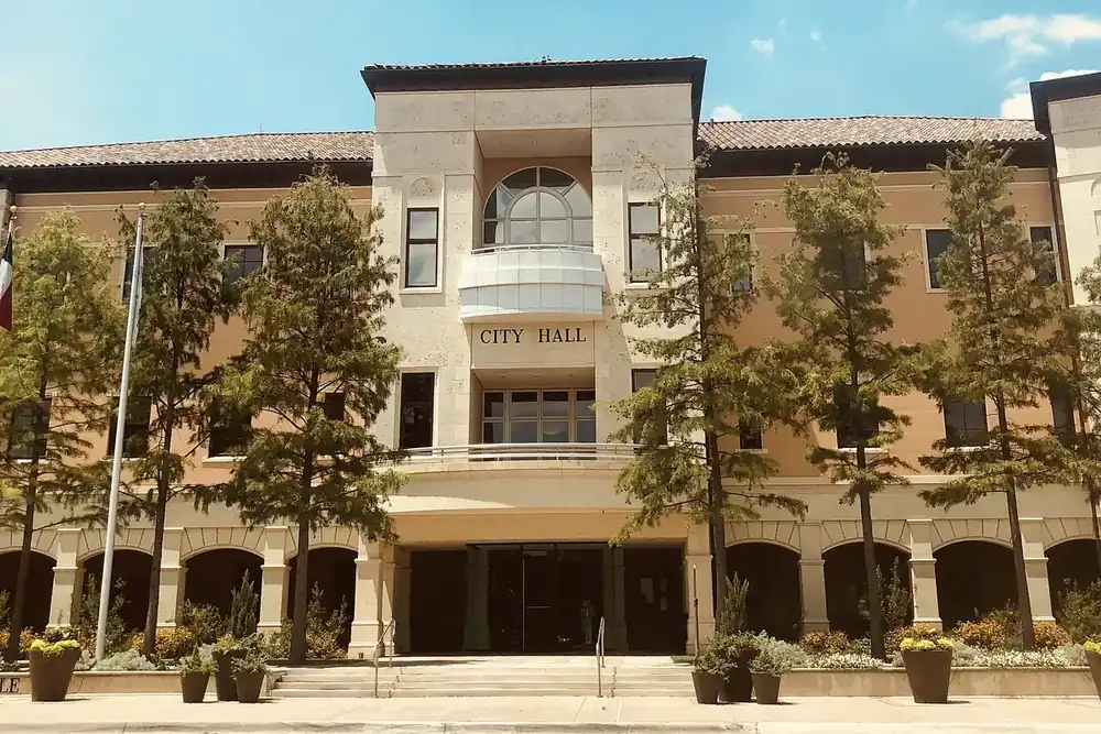 Colleyville City Hall with a tiled roof, arches and trees in Colleyville, Texas