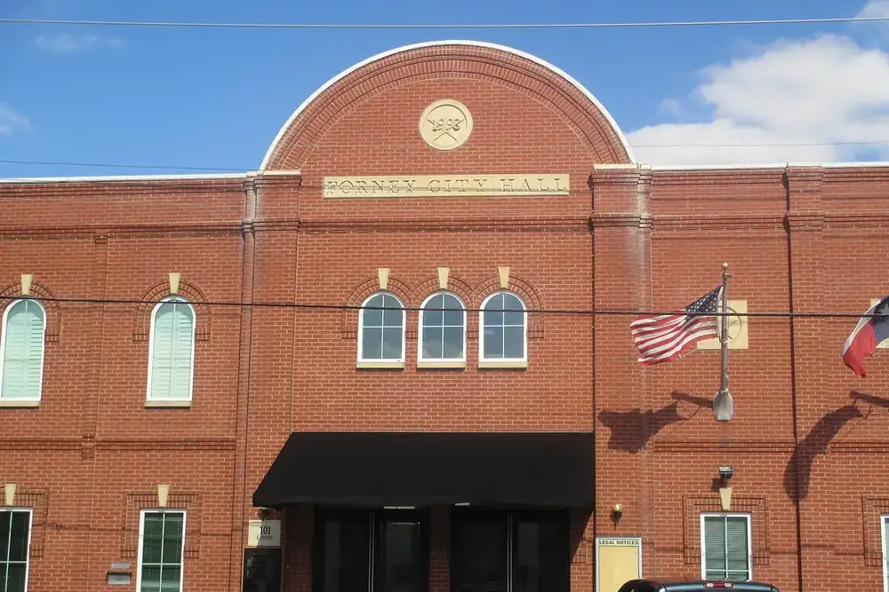 Forney City Hall red brick building with arched windows and flags in Forney, Texas