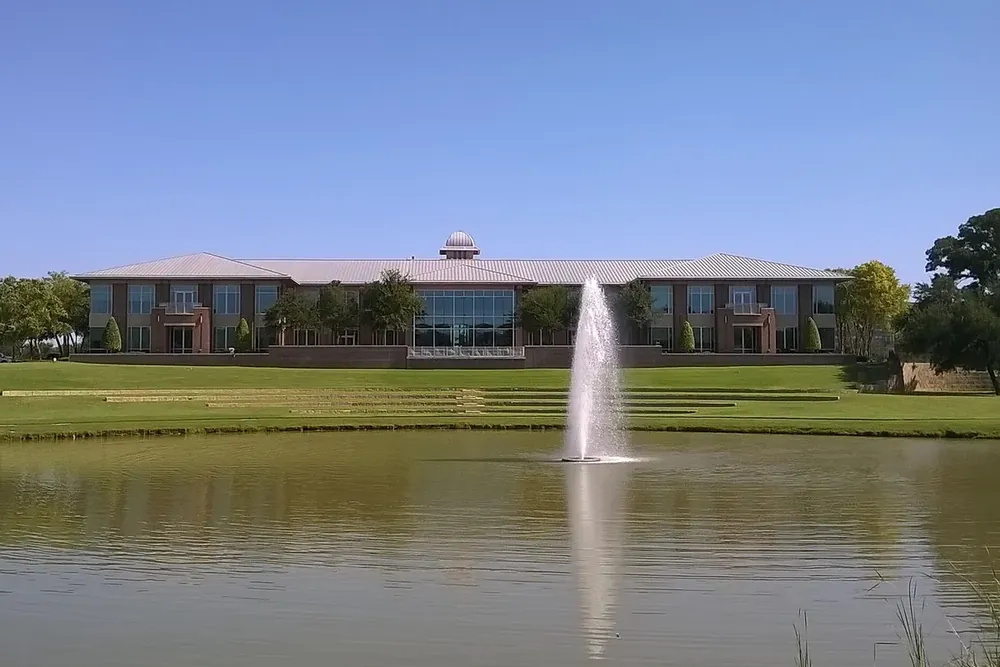 Keller Town Hall behind a pond with a fountain in Keller, Texas
